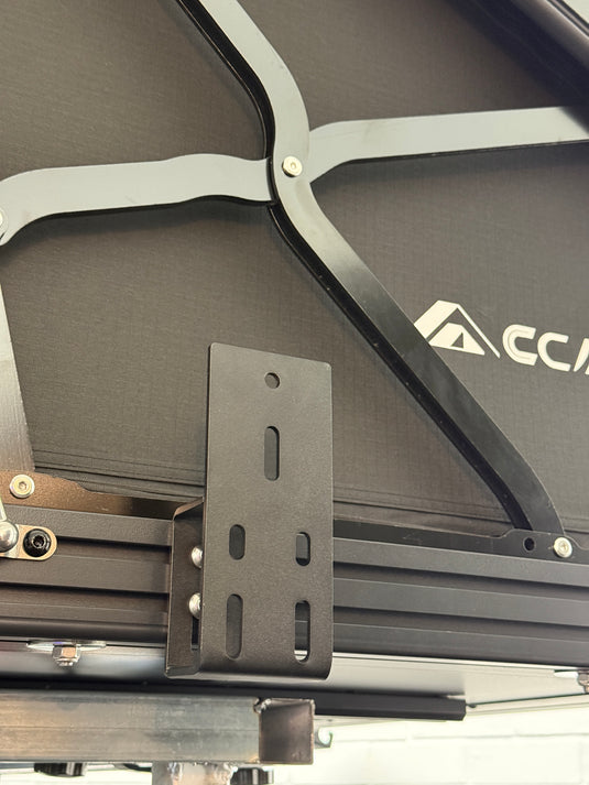 Close-up of a black metal bracket attached to a larger mechanical structure with 'Accu' branding.