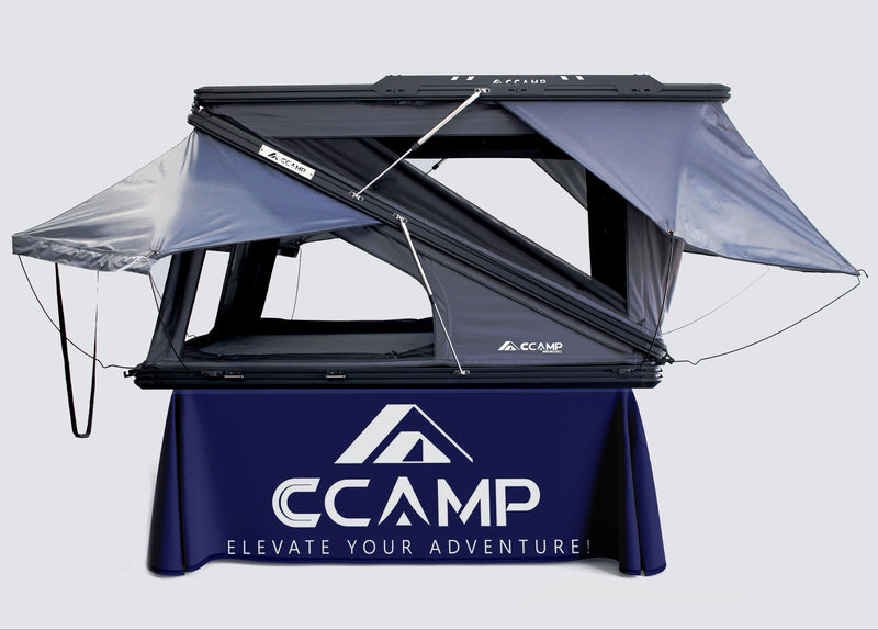 Load image into Gallery viewer, CCamp roof top tent on a stand with a branded tablecloth against a white background
